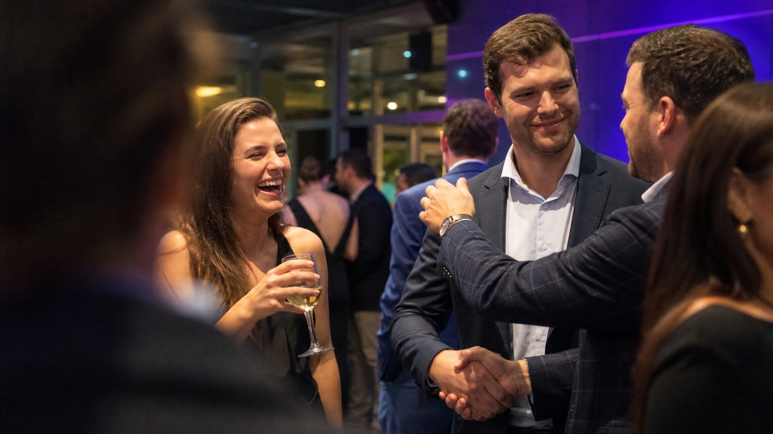 Guests talking and shaking hands at an evening reception during a corporate incentive trip.